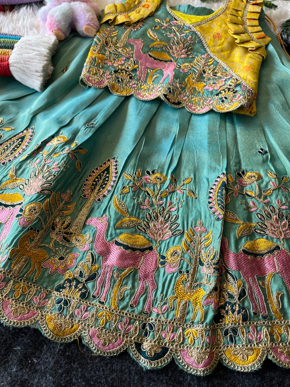 Cyan embroiderey fabric with intricate designs on a dark surface