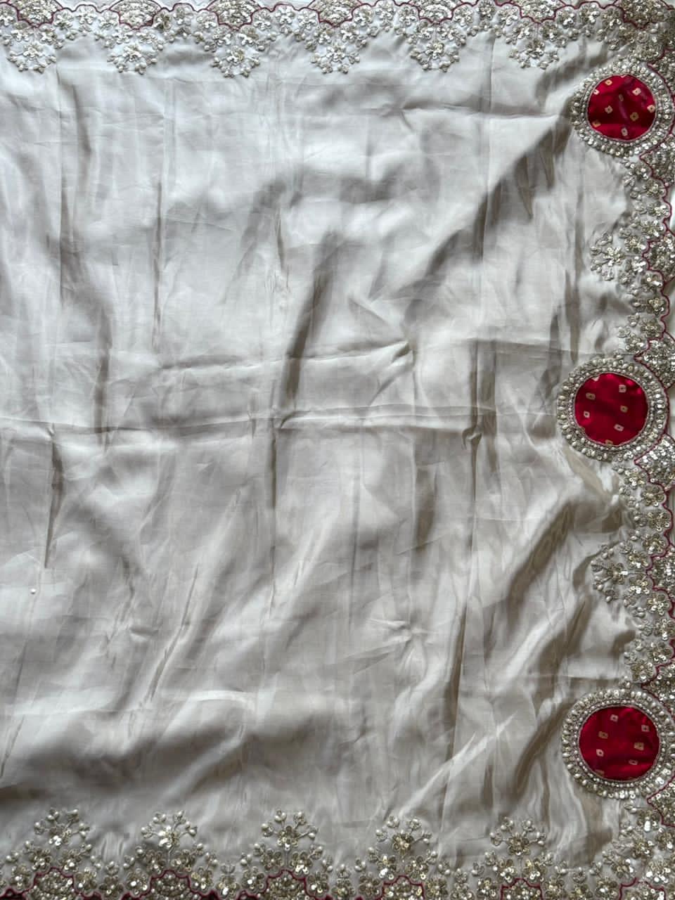 White fabric with red and silver embellishments