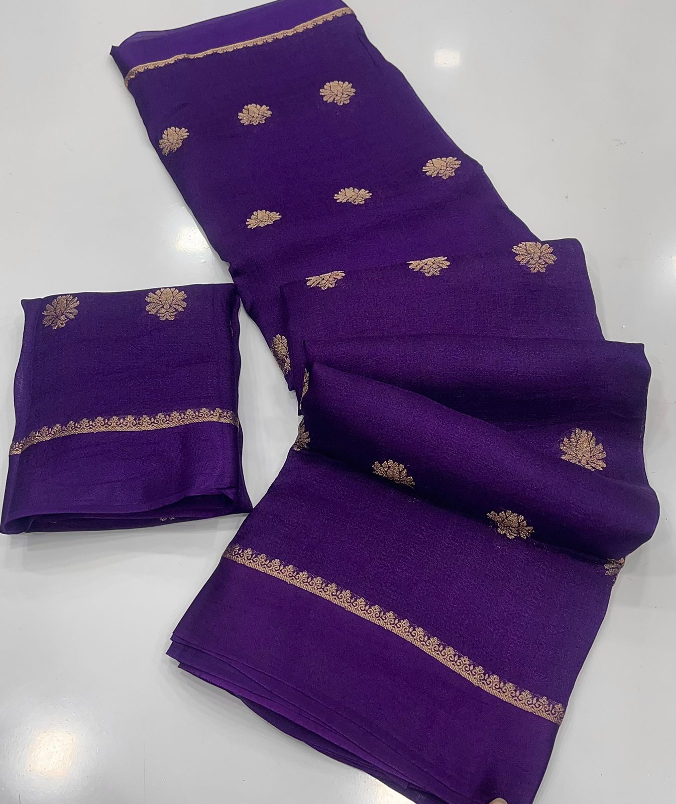 Purple saree with gold embroidery on a white background
