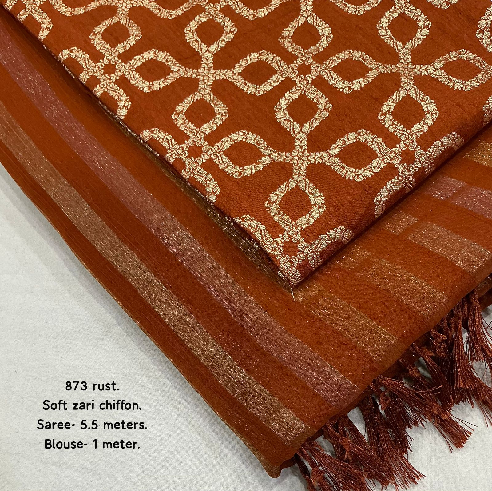 Brown saree with intricate gold pattern on a light gray background