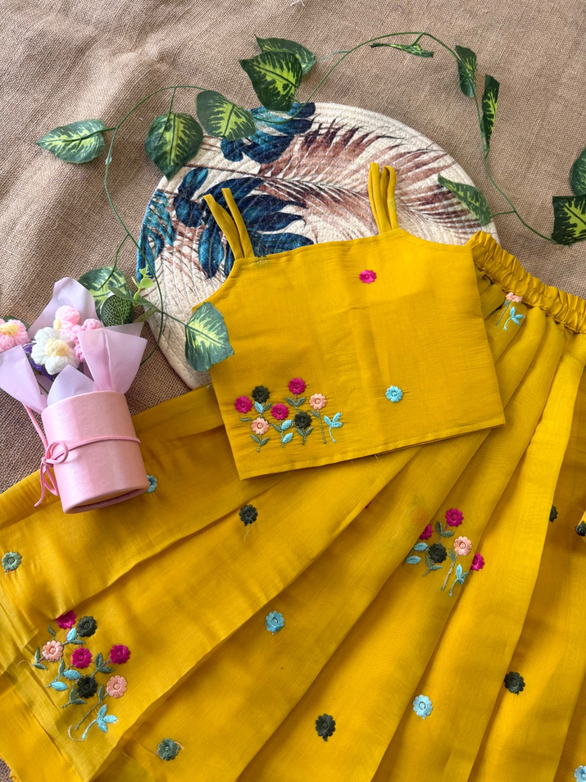 Mustard Yellow traditional outfit with floral embroidery on a beige fabric background