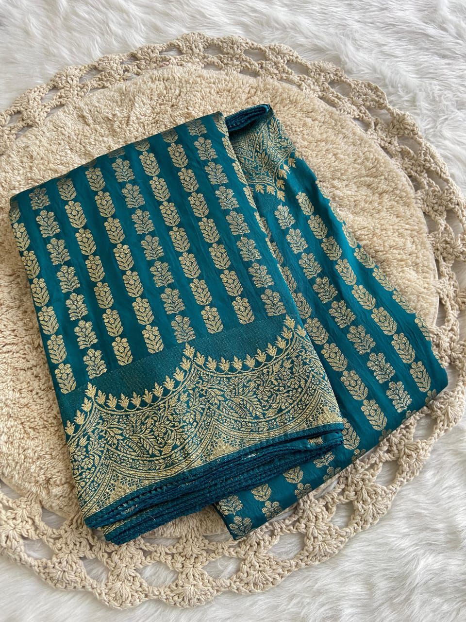 Rama green fabric with gold patterns on a texture surface