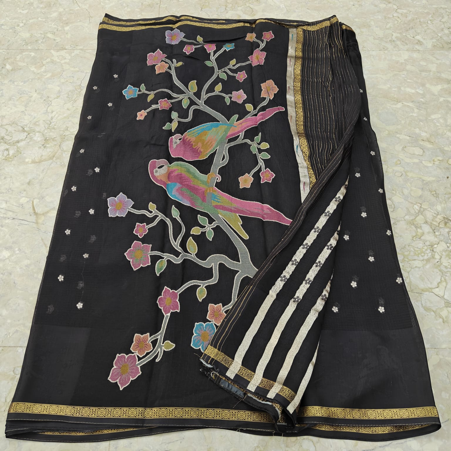 Black saree with colorful parrot and floral patterns 