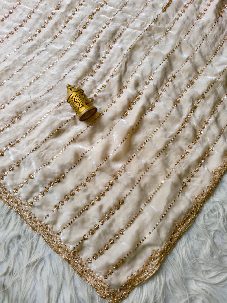 Gold decorative item on a textured cream fabric background