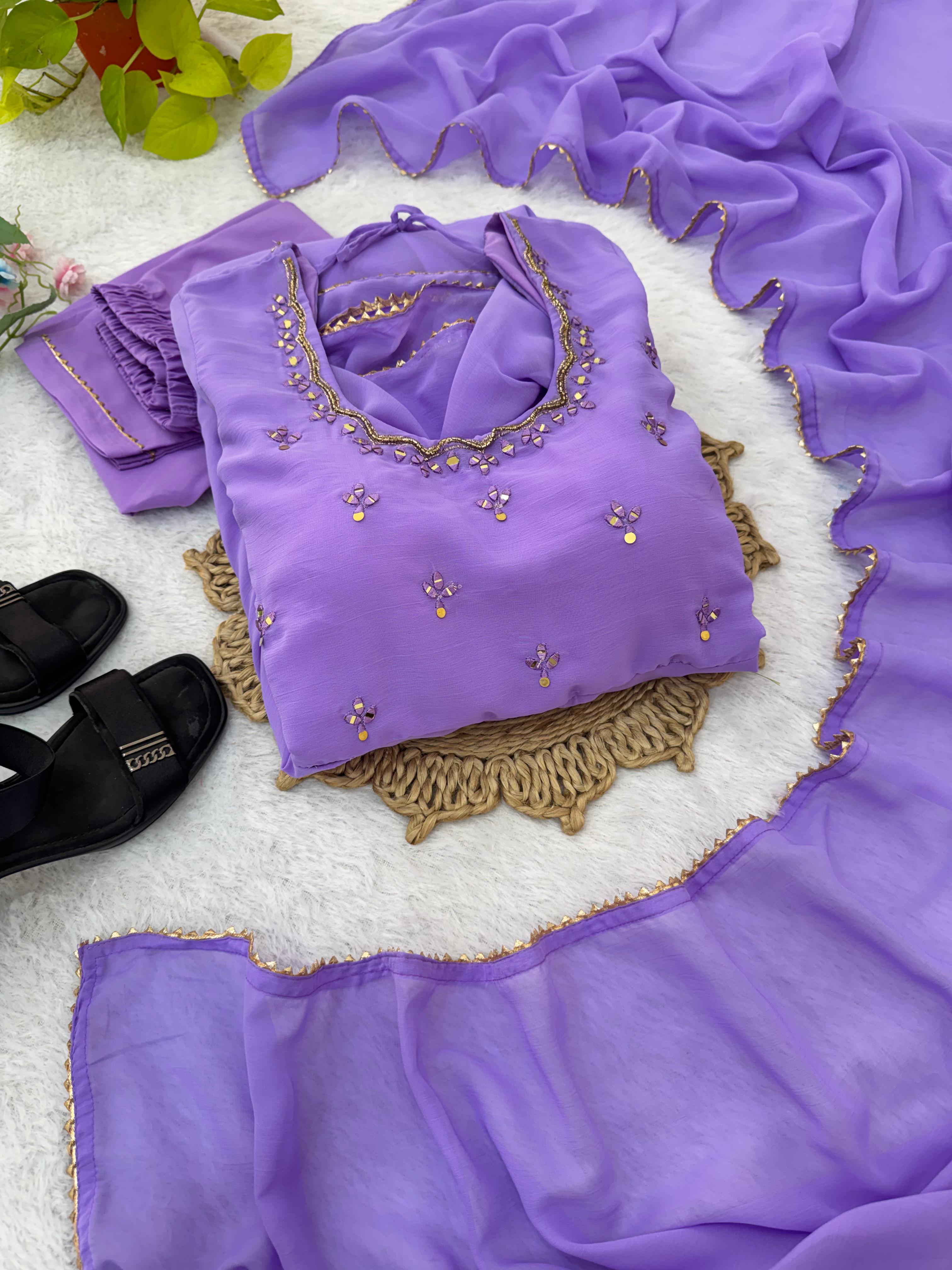 Purple dress with floral embroidery on a surface with a floral background