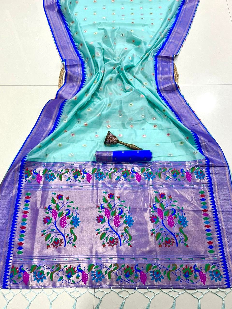 Light blue saree with floral patterns and a border on a background