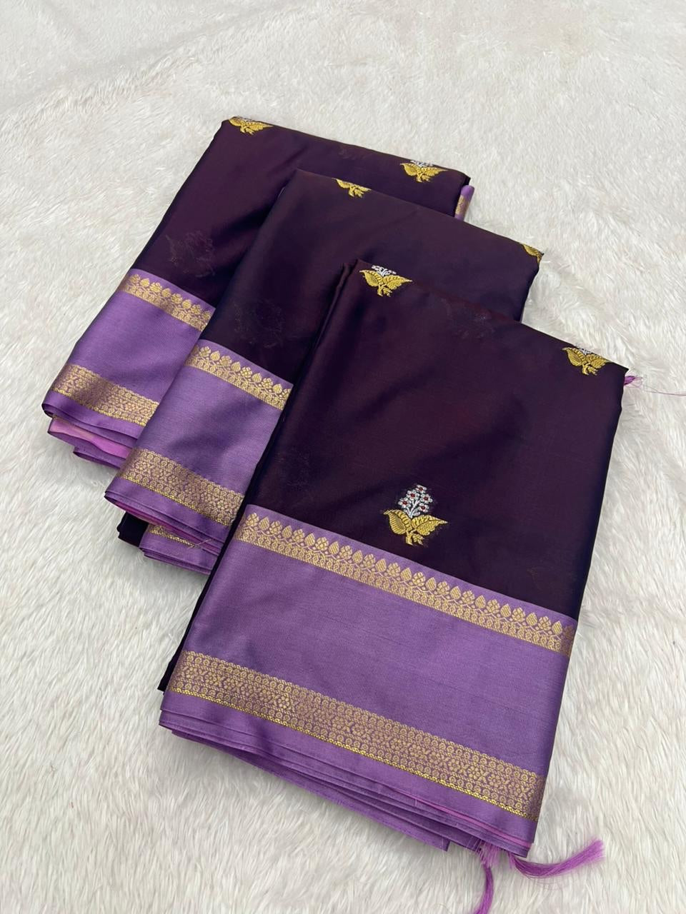 Purple saree with gold border and floral design on a white background