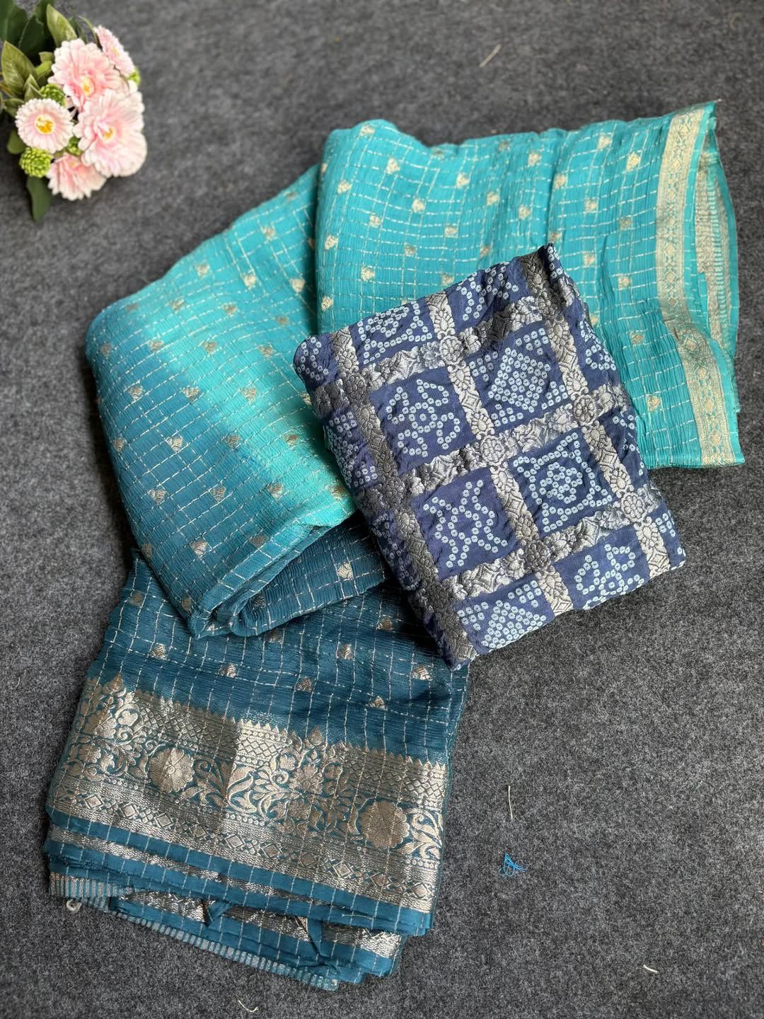 Rama Green saree with floral patterns on a dark surface with flowers.
