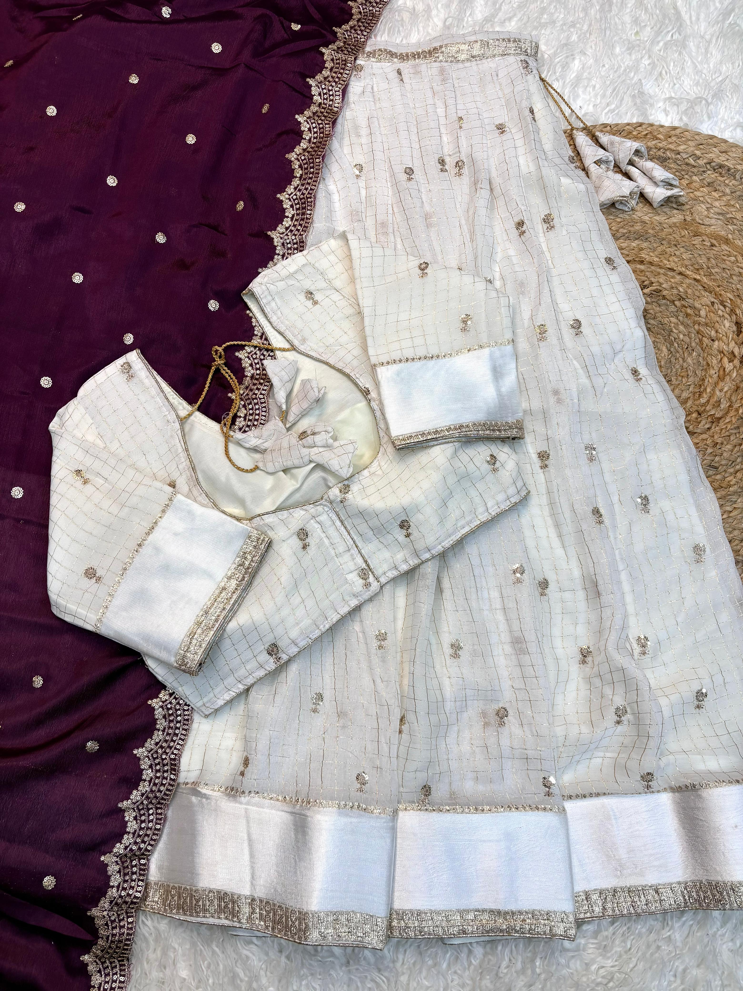 White embroidered blouse with wine saree on a textured surface