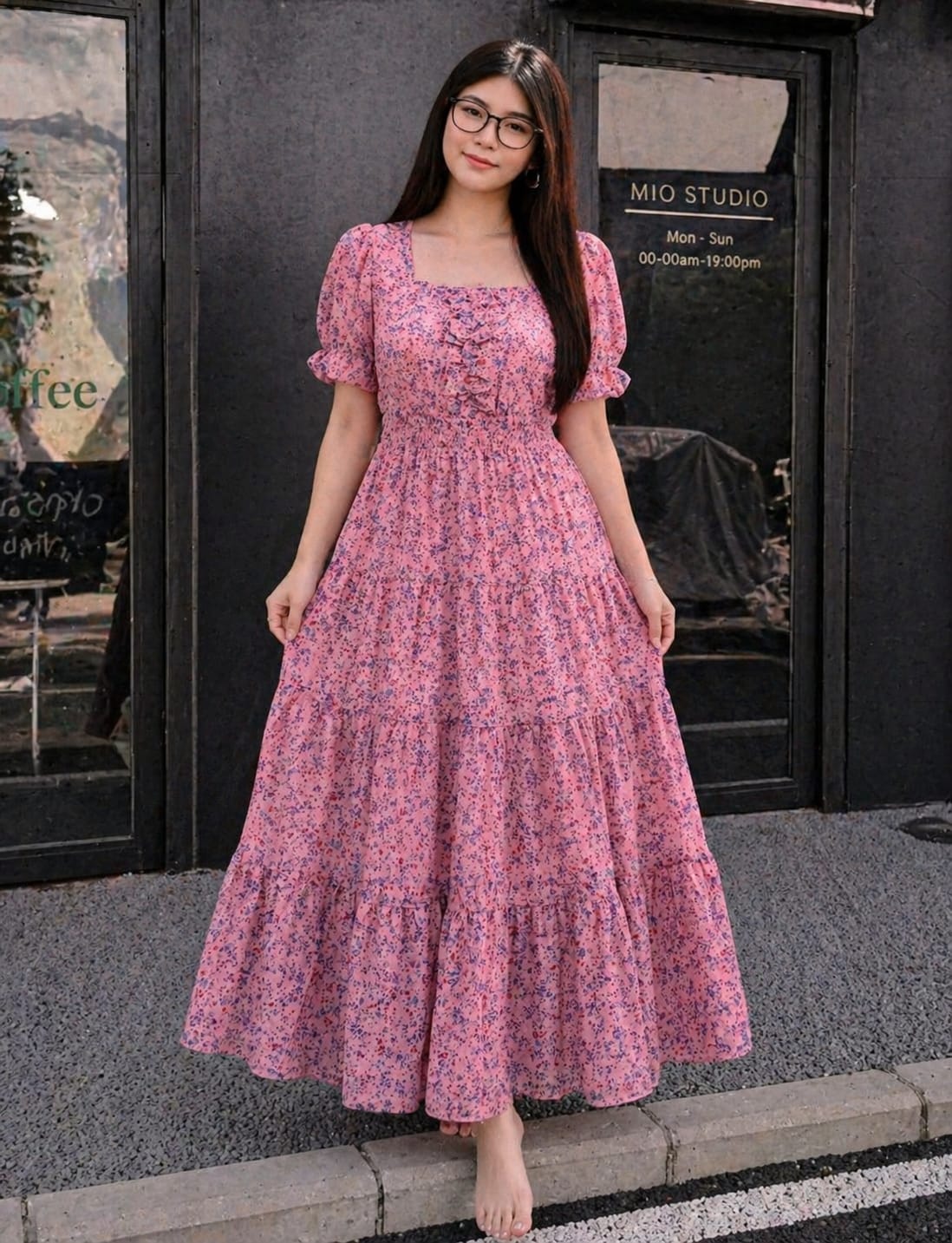 Woman wearing a Baby pink floral dress standing on a street in front of a building.