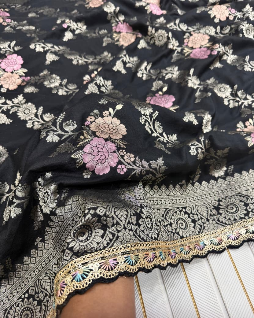 Black fabric with floral embroidery and gold border on a white background