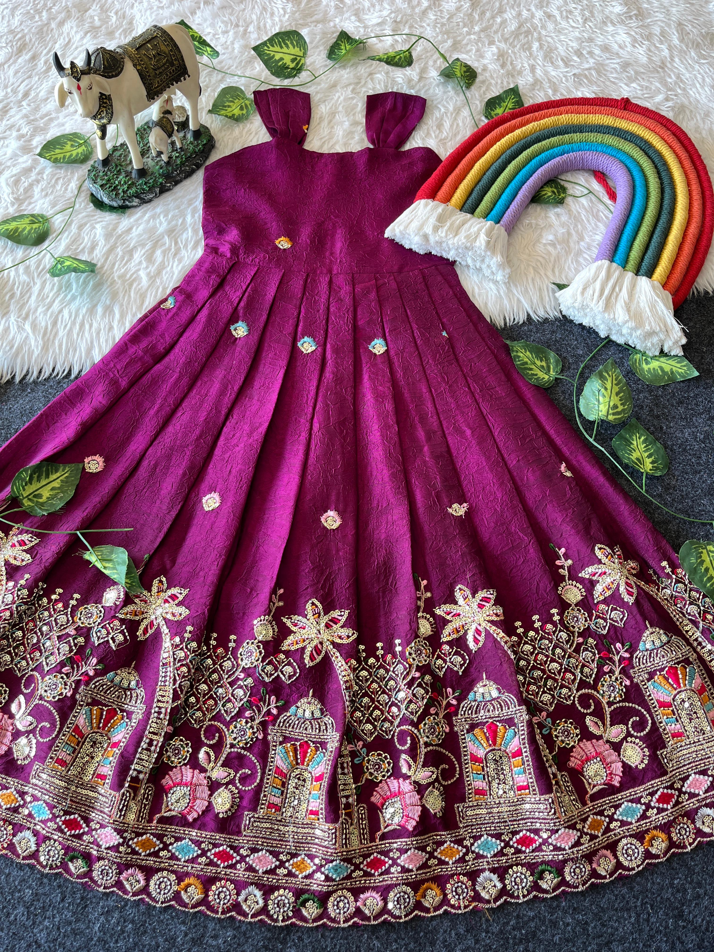 Rani pink embroiderey dress with decorative elements on a textured surface