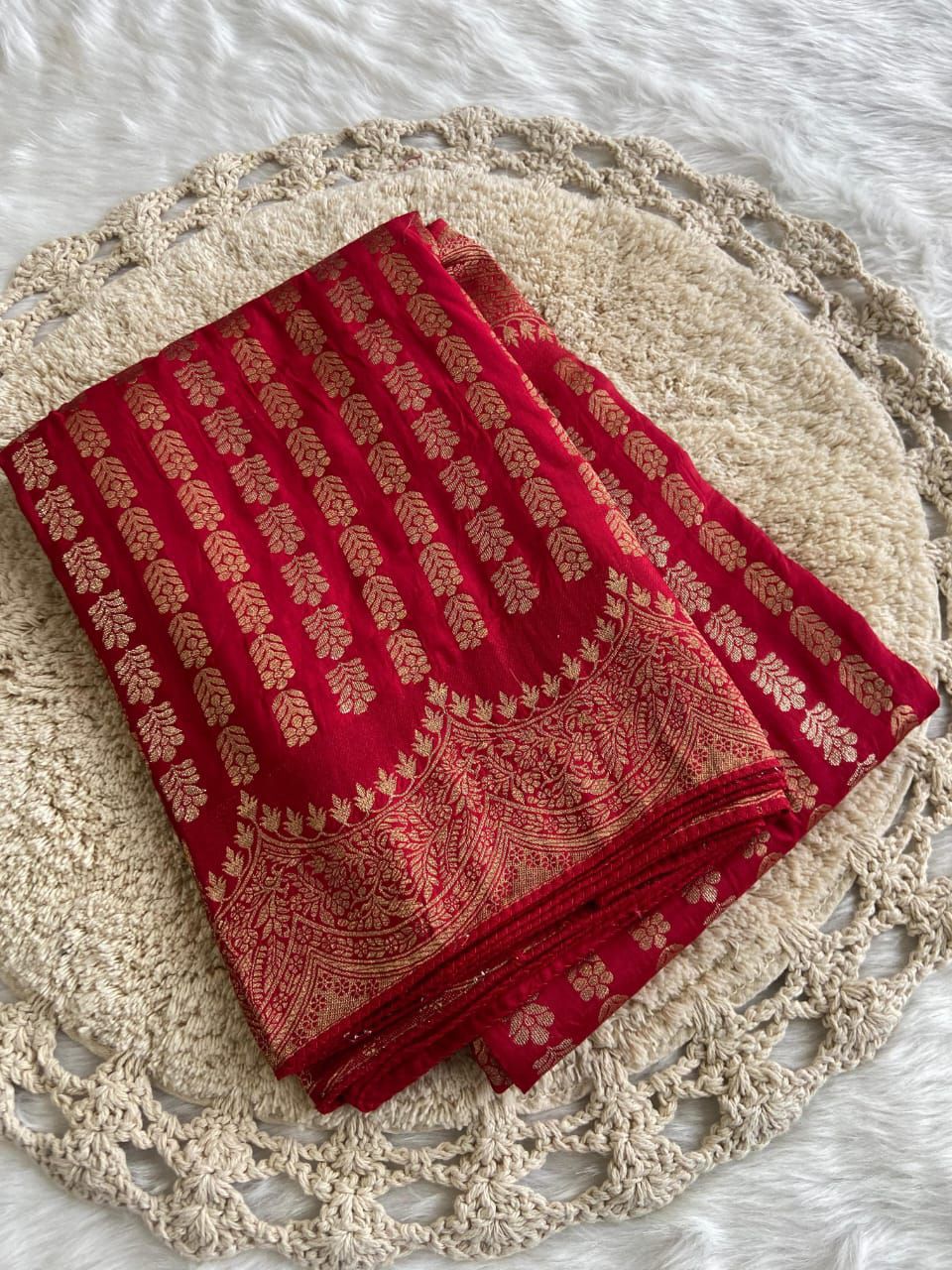 Red fabric with gold patterns on a texture surface
