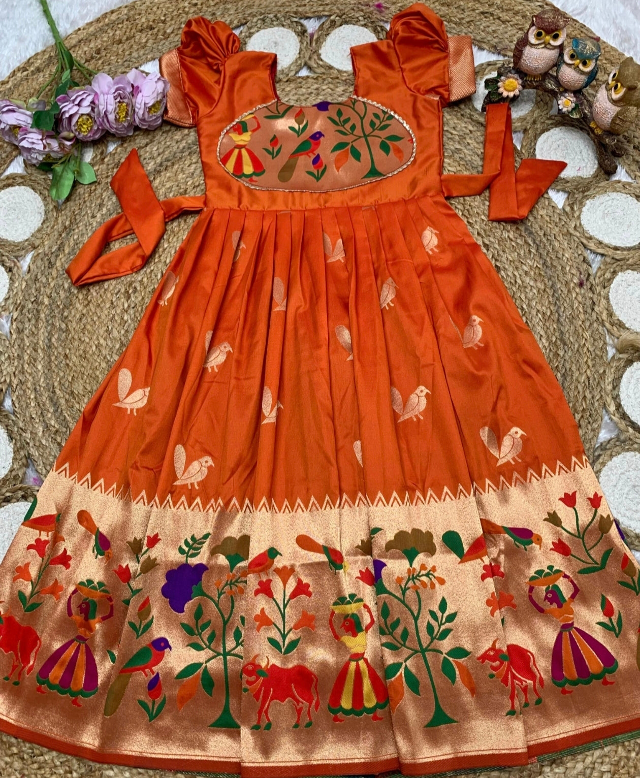 Orange dress with intricate patterns on a texture surface