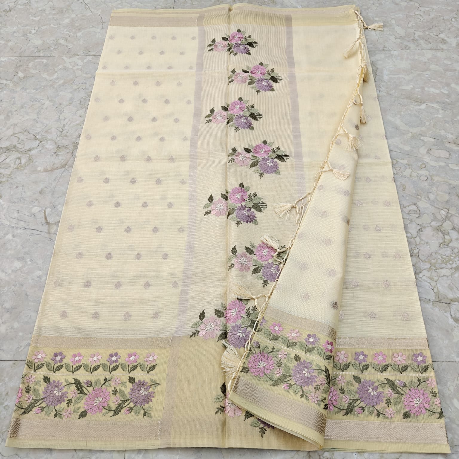 Beige saree with floral patterns on a floor