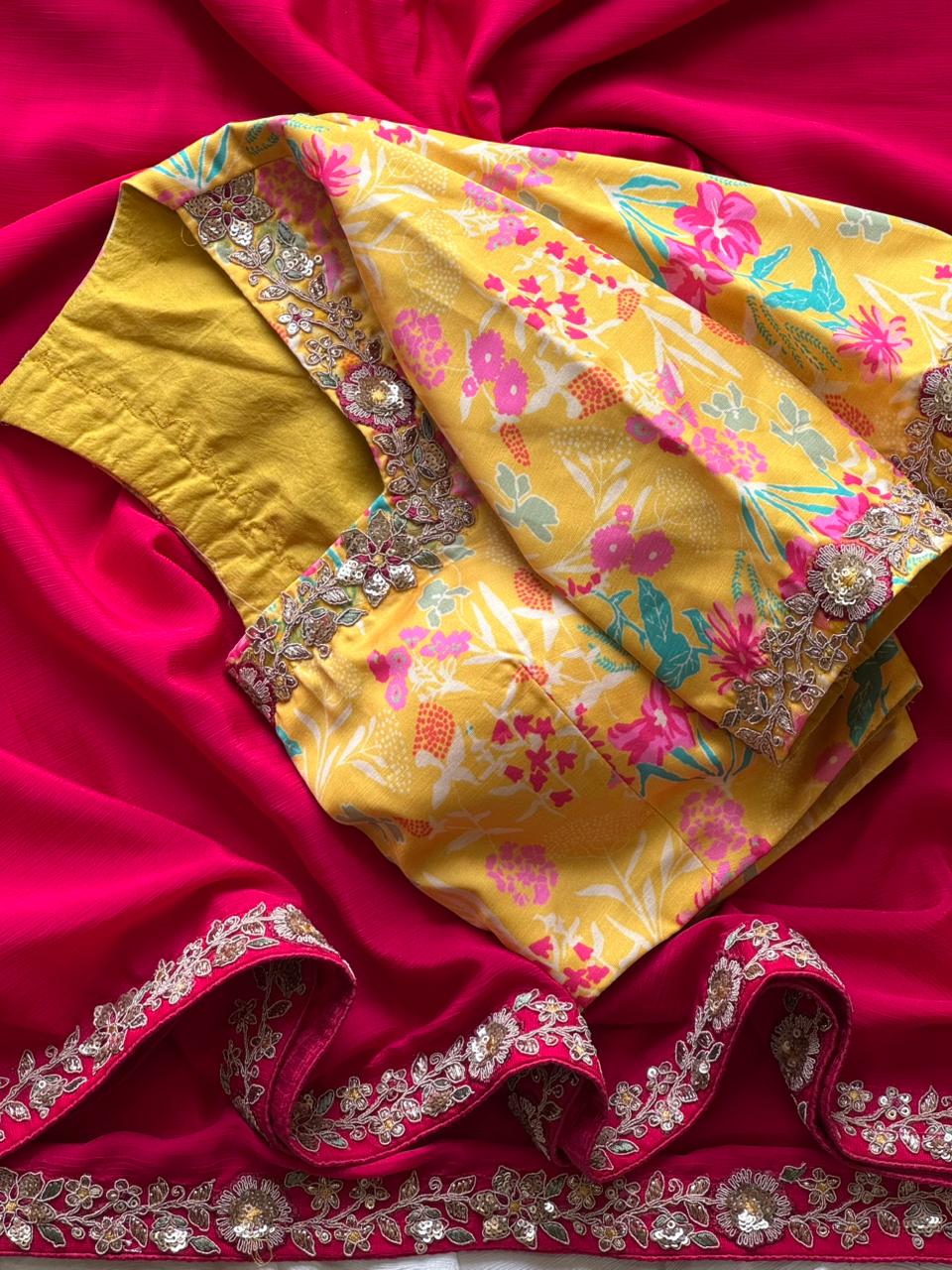 Pink saree with floral patterns and border on a fabric background with yellow blouse 