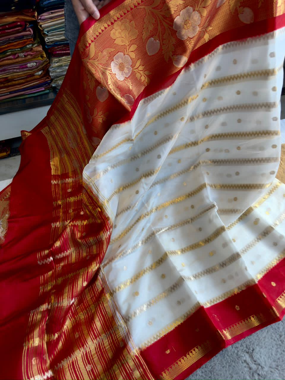 Saree with red and gold patterns on a white background