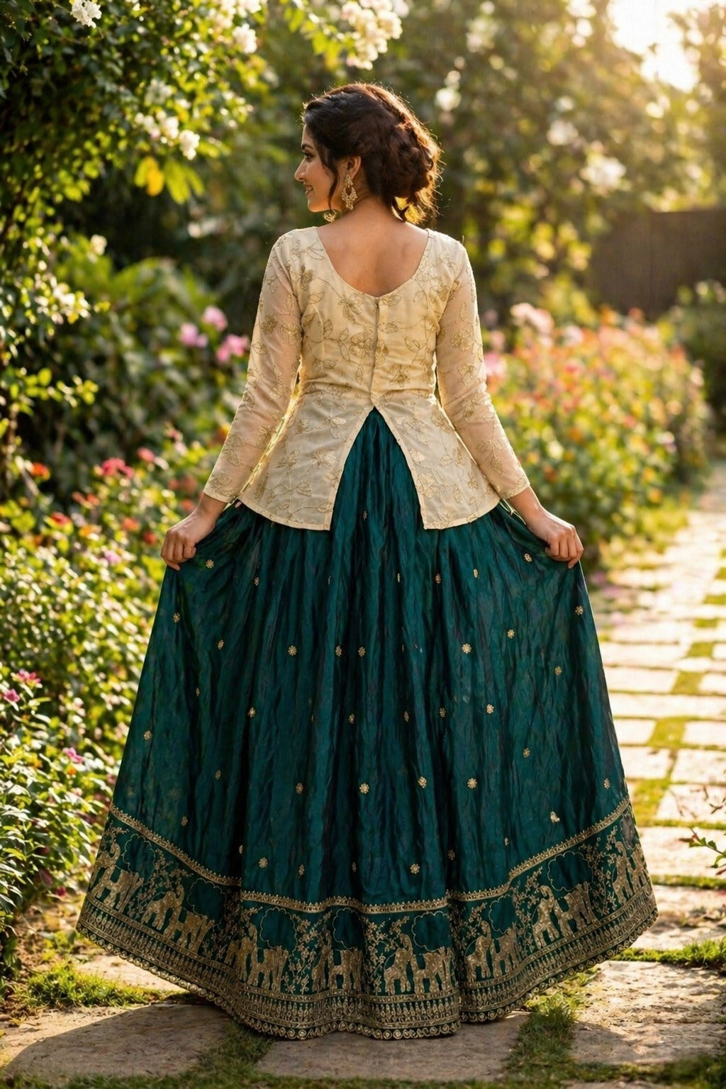 Woman in a dark green and cream traditional outfit standing in a garden.