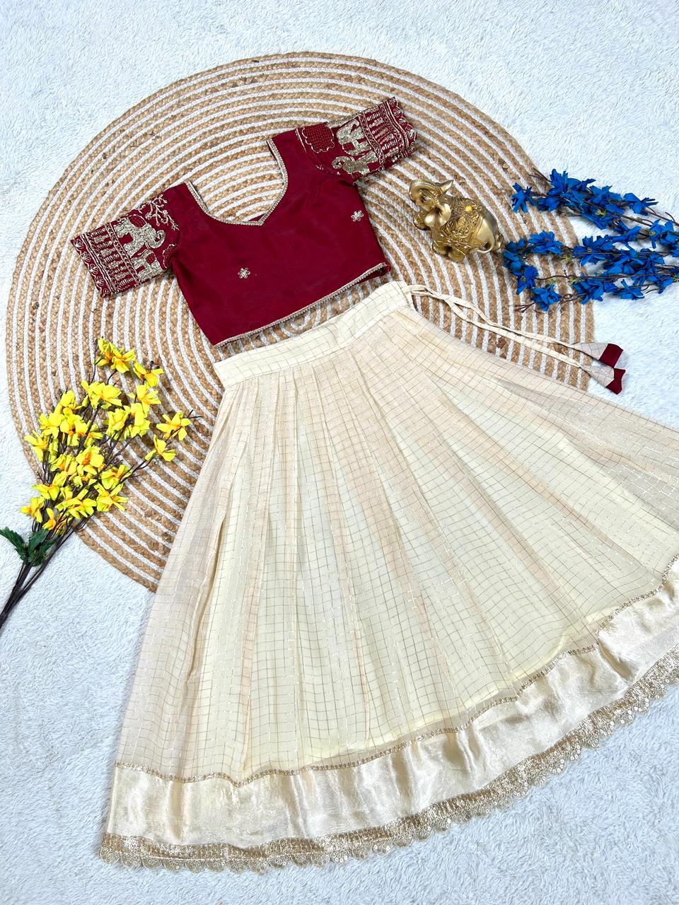 Red blouse with cream skirt on a decorative mat with flowers and jewelry.