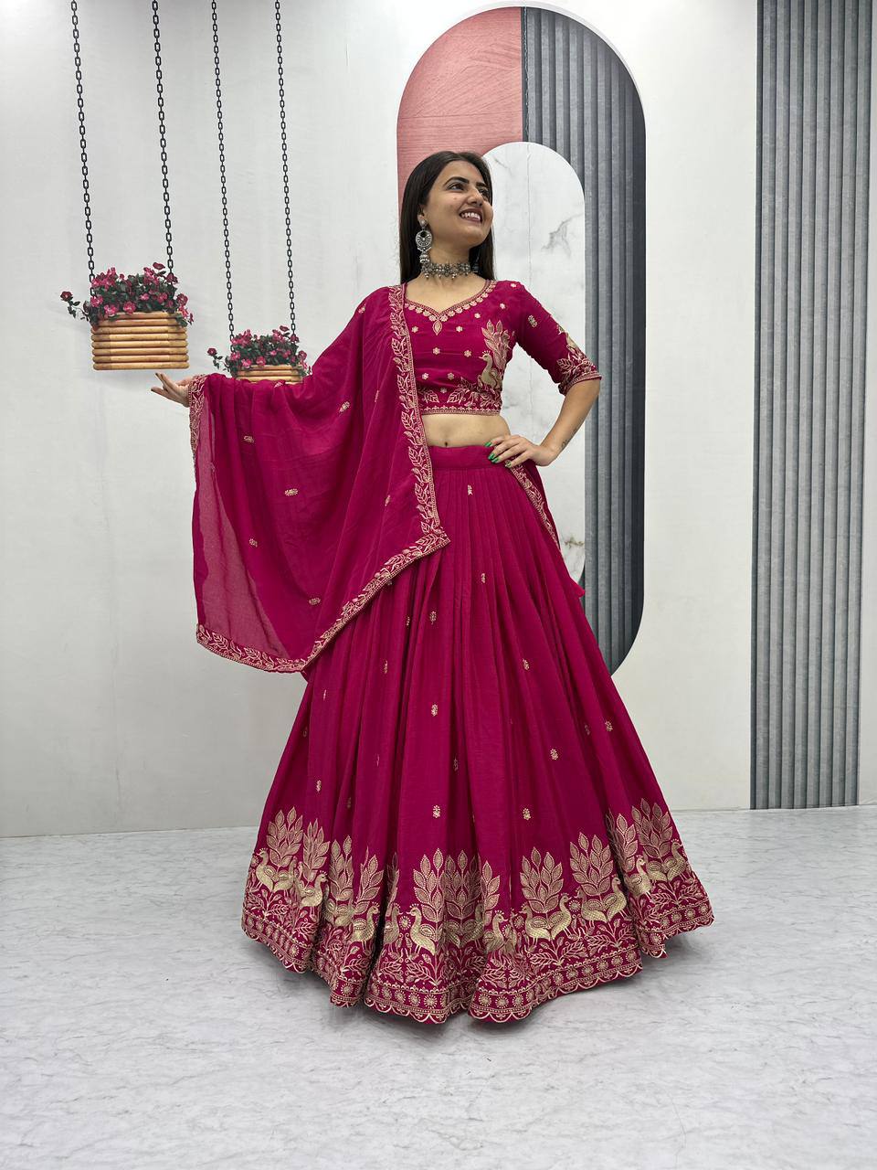 Woman in a pink embroidered traditional outfit standing in front of a mirror.