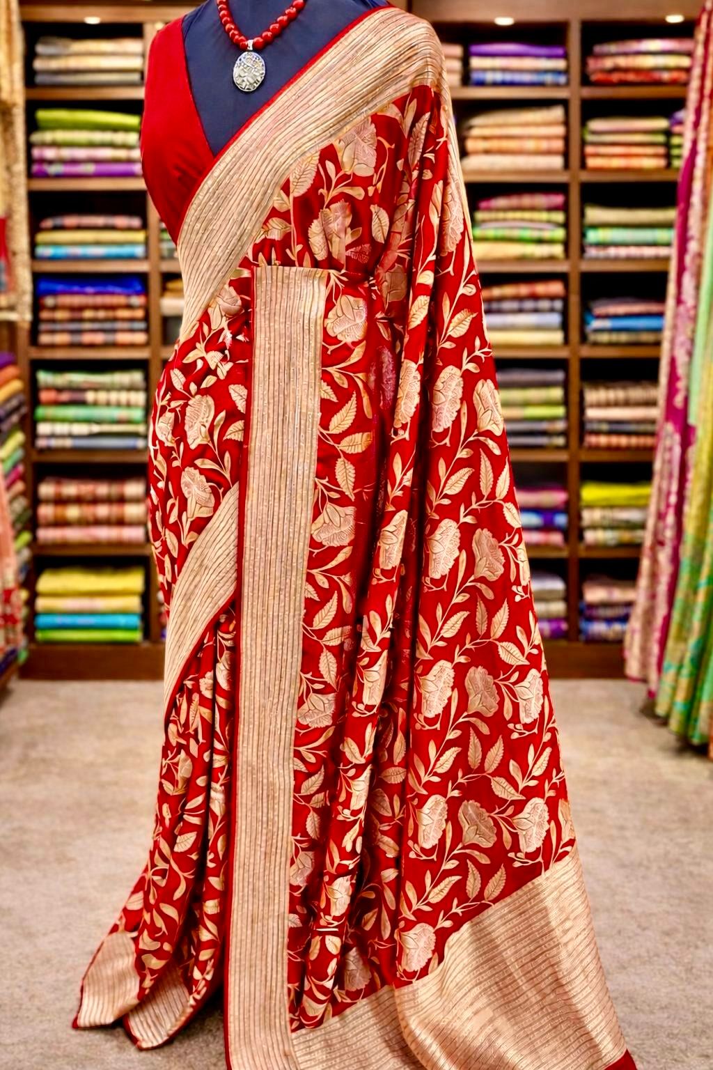 Red saree with floral patterns in a store setting