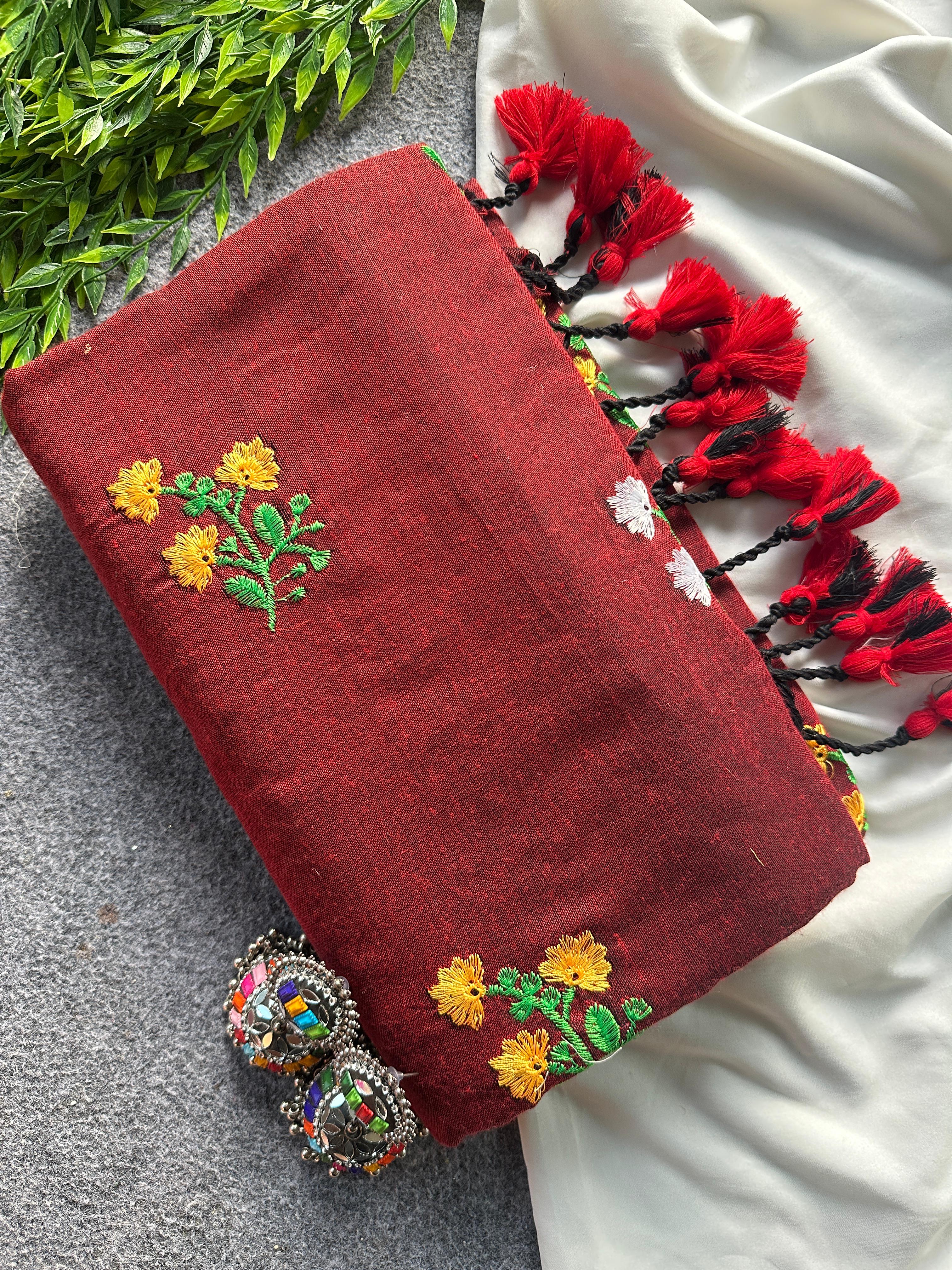 Maroon fabric with floral embroidery and tassels