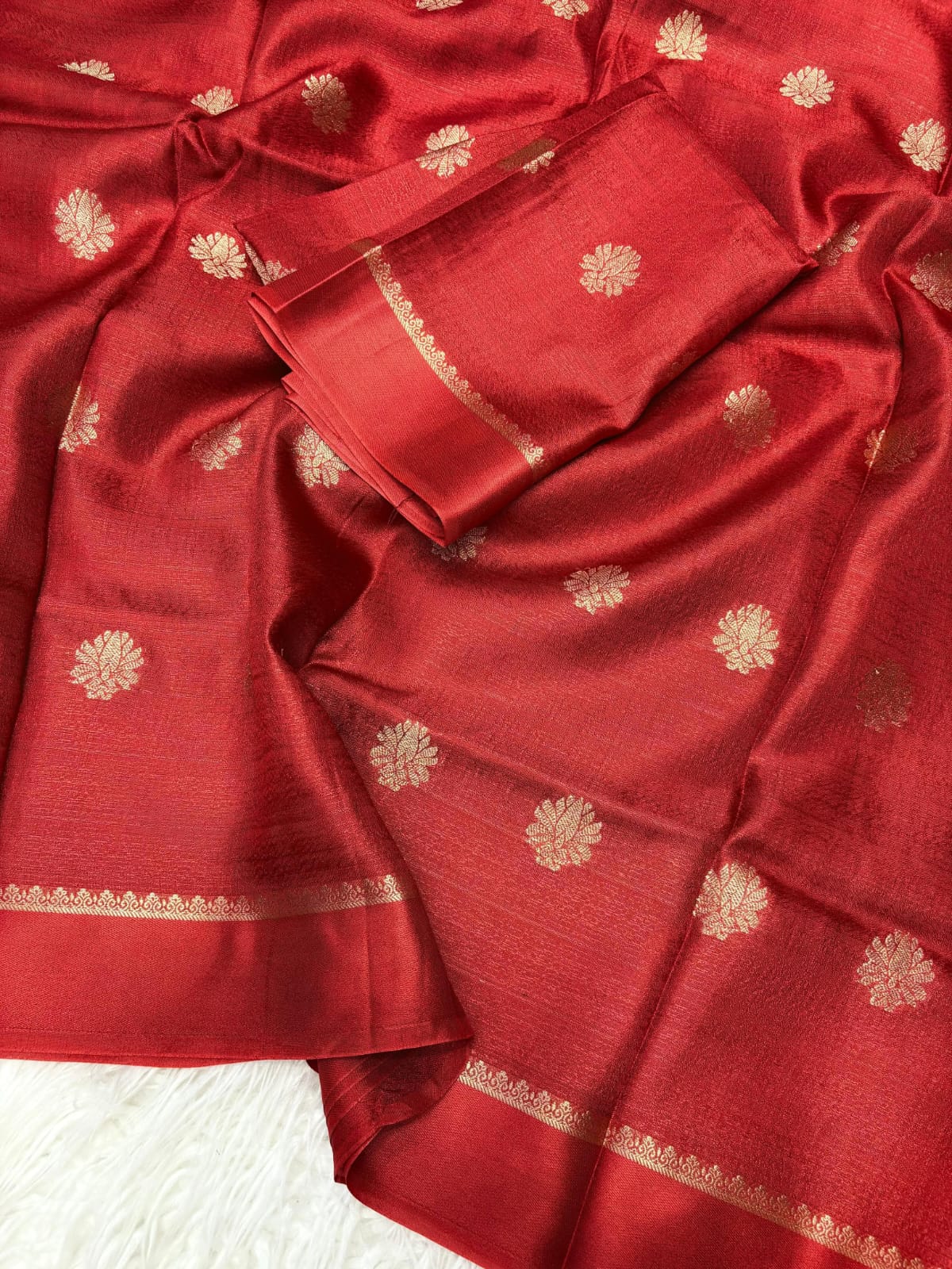Red fabric with gold patterns on a white background