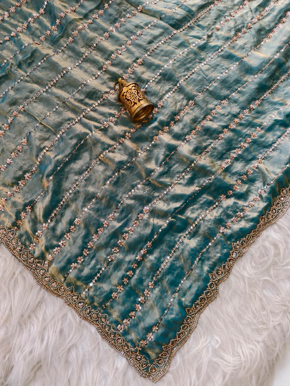 Turquoise Blue with gold embroidery and a decorative object on a white background