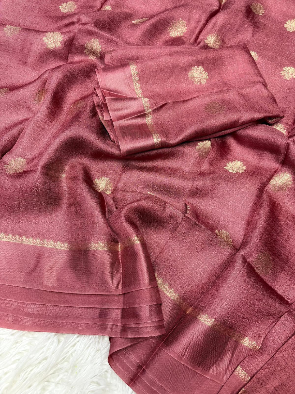Onion pink saree with gold patterns on a white background