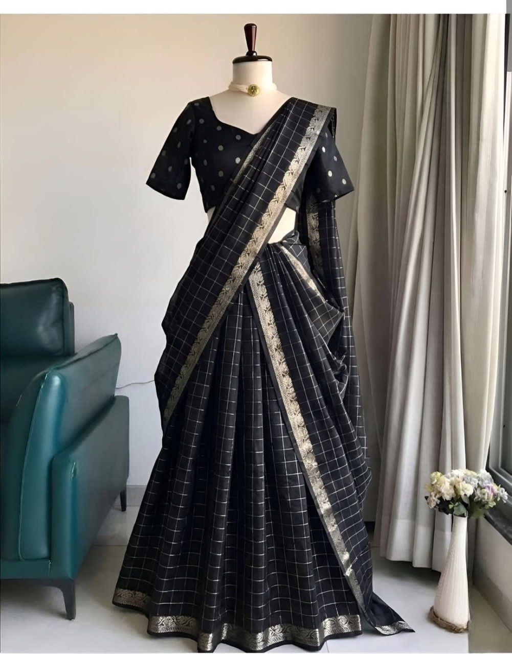 Black saree with silver border on a mannequin against a neutral background