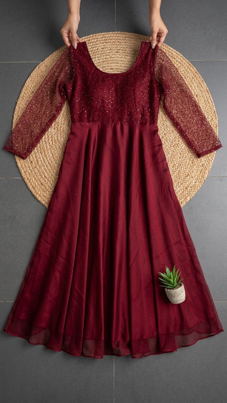 Red dress with sheer sleeves held up against a gray background