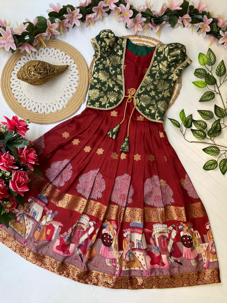 Traditional maroon embroidered saree with a  blouse on a decorative background with flowers and leaves.