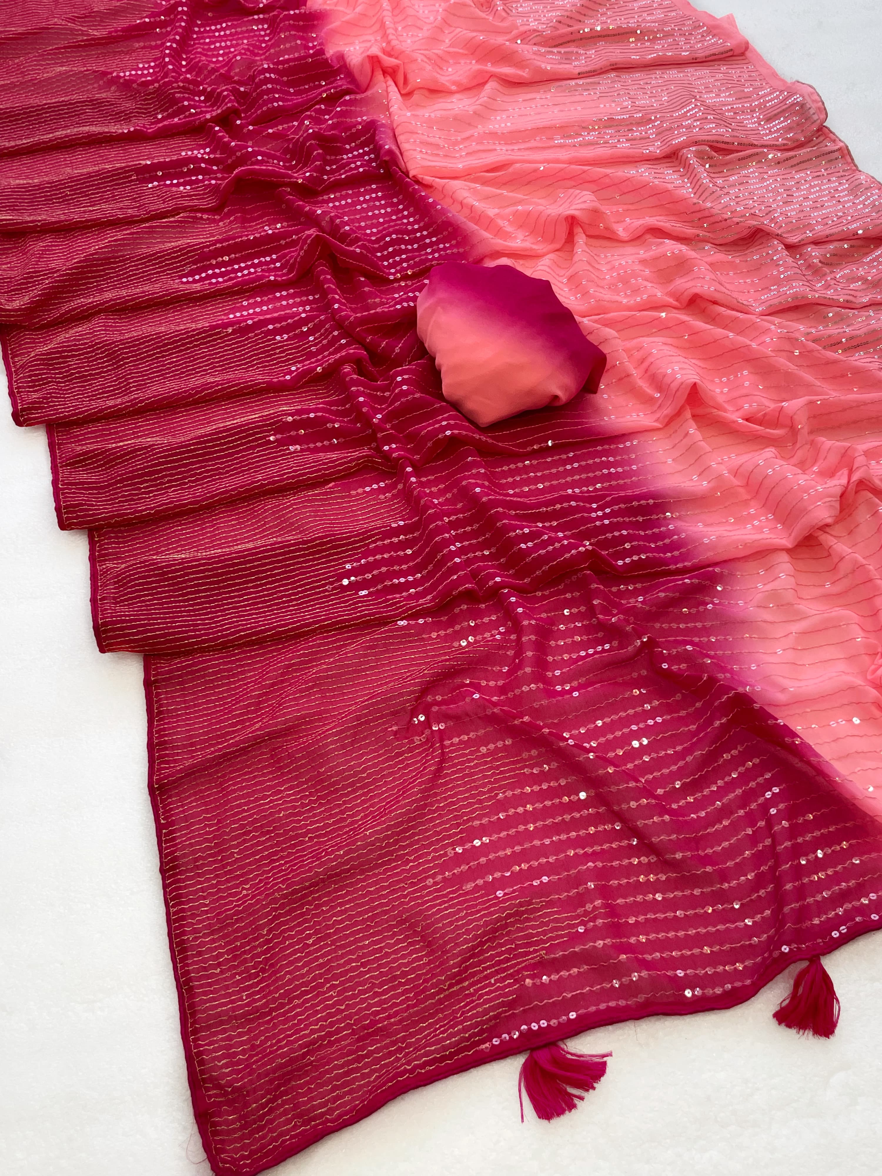 Pink ruffled fabric with tassels on a white background