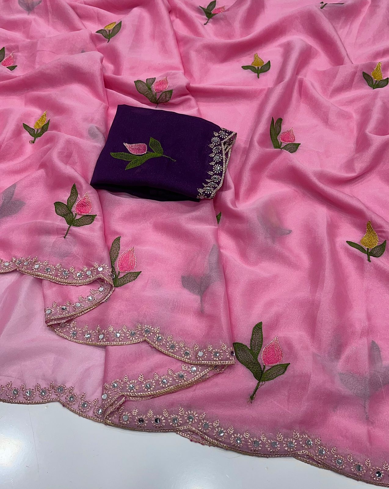 Baby Pink saree with floral embroidery and a blouse on a matching pink fabric background.