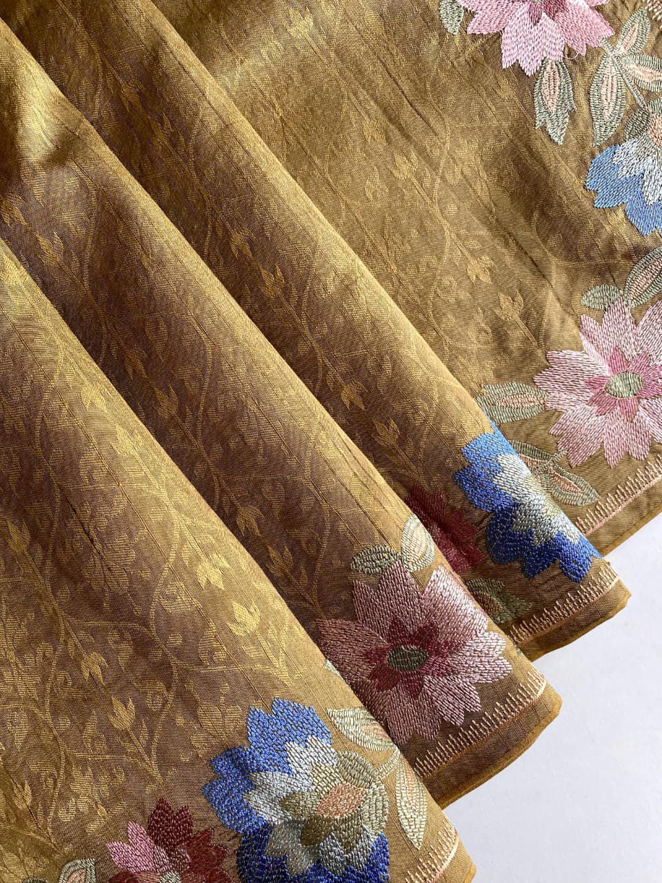 Gold fabric with floral patterns on a brown background