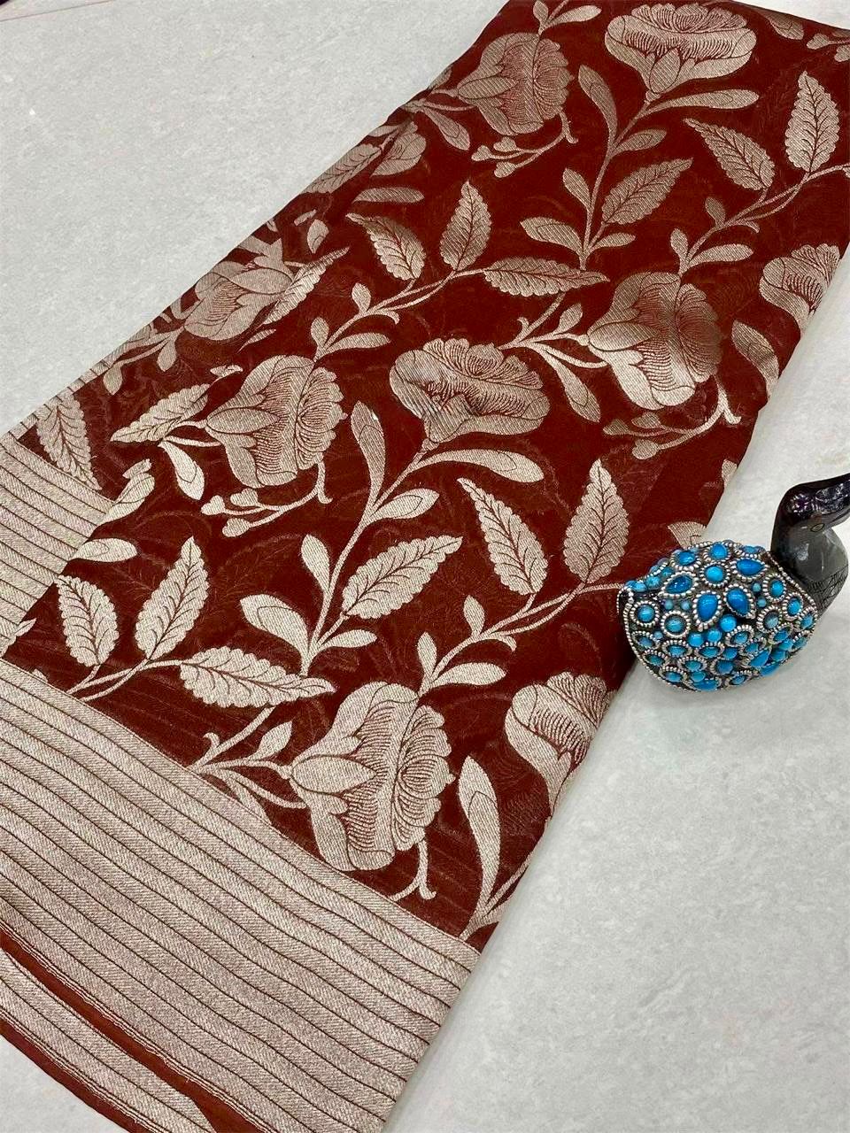 Brown floral patterned fabric with a decorative brooch on a light gray background