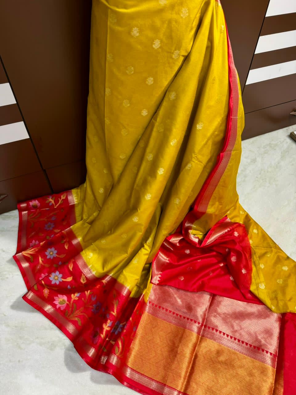 Mustard Yellow saree with a decorative bow on a striped background