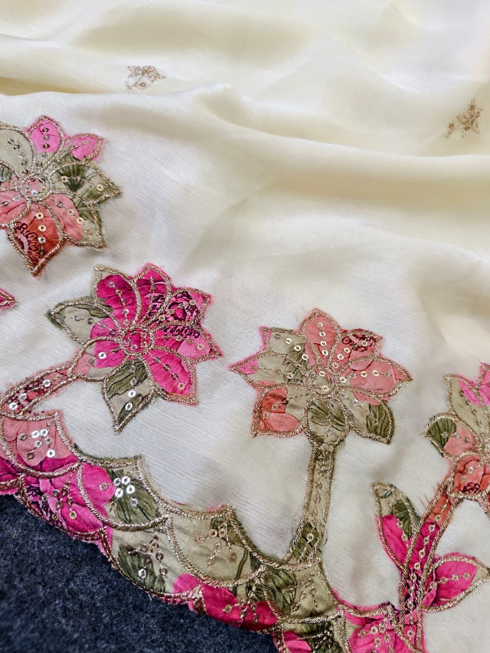 White fabric with pink and green floral patterns on a white background