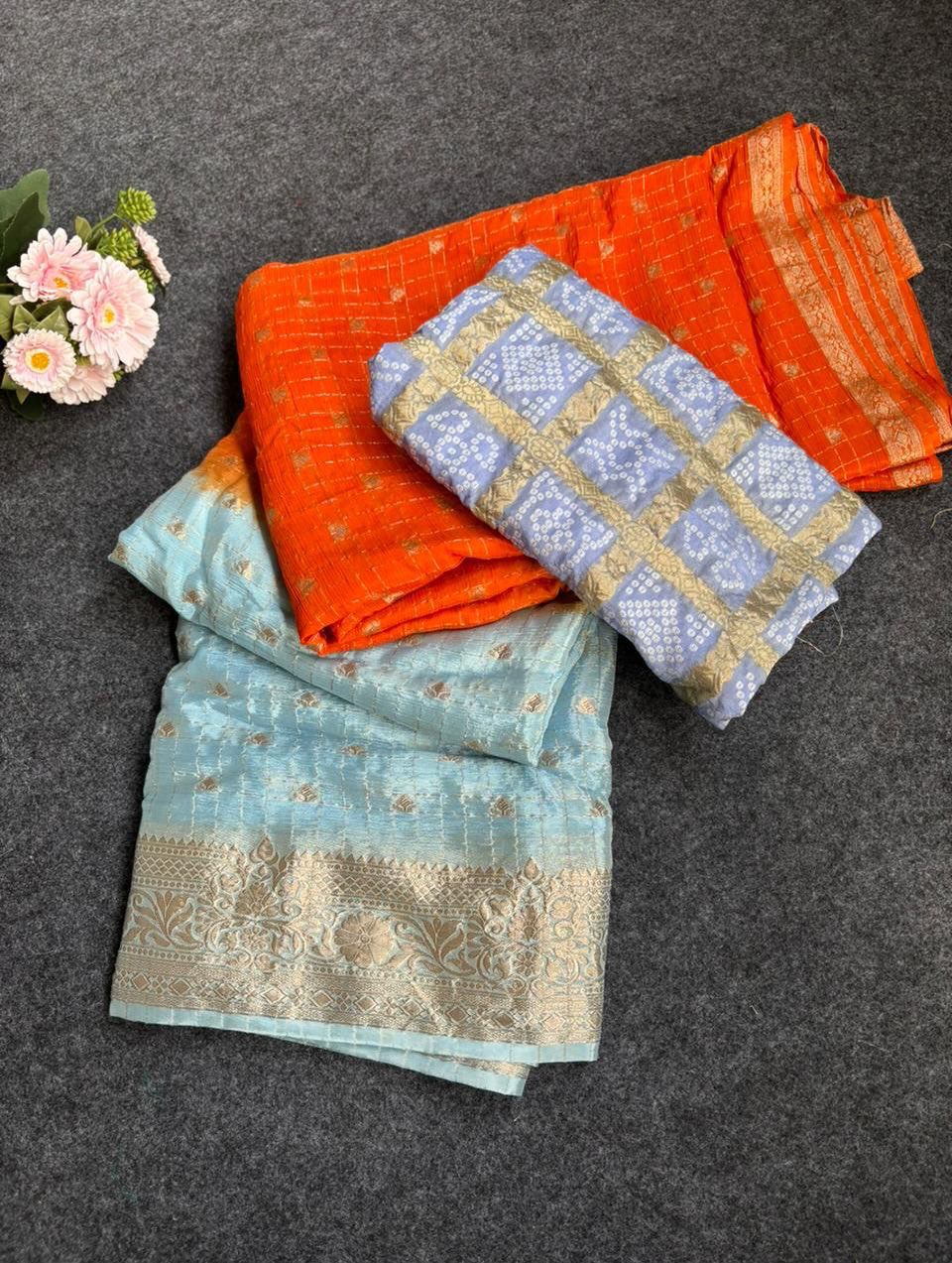 Cyan fabric with floral patterns on a dark surface.