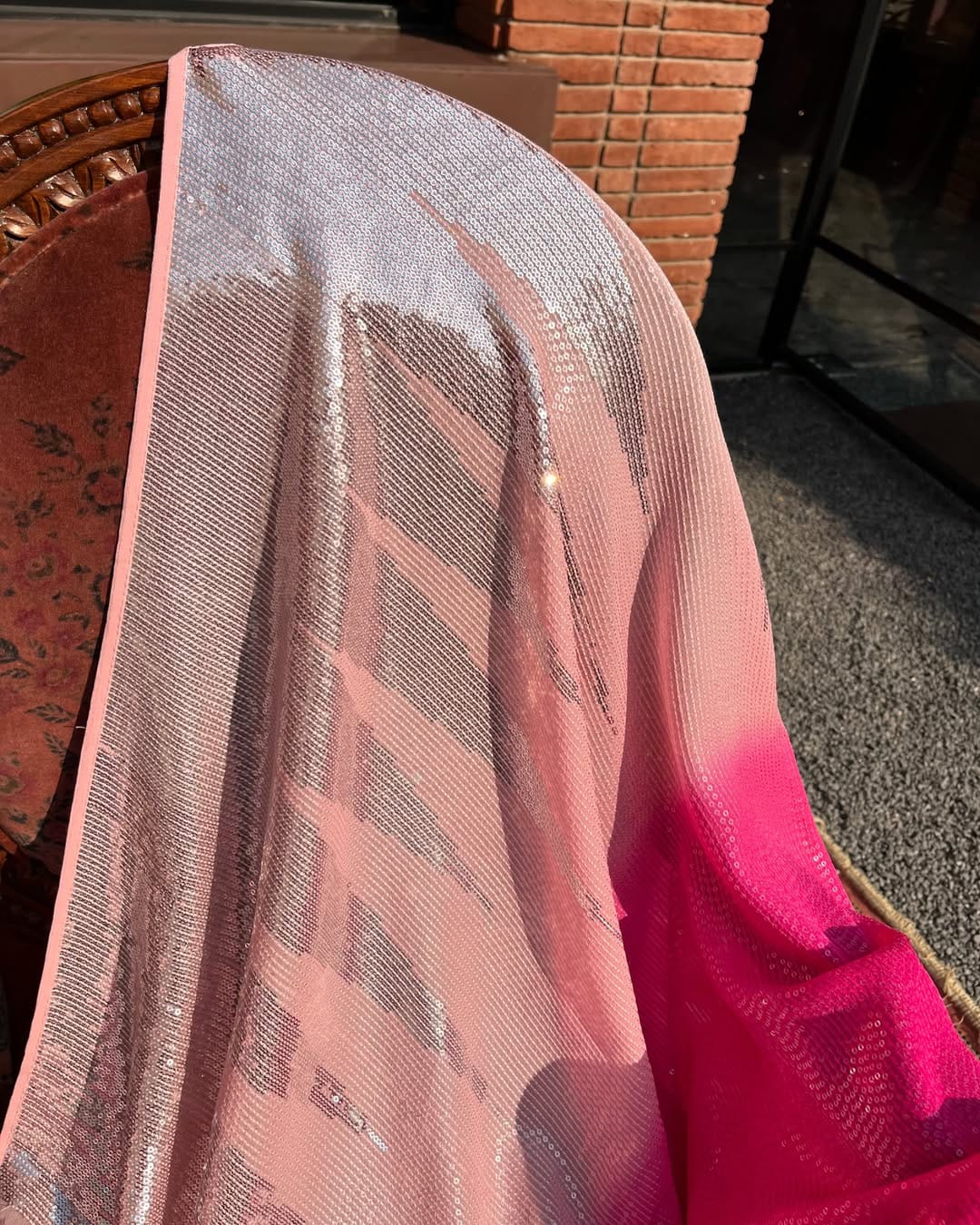 Close-up of a pink and silver patterned fabric with a blurred background