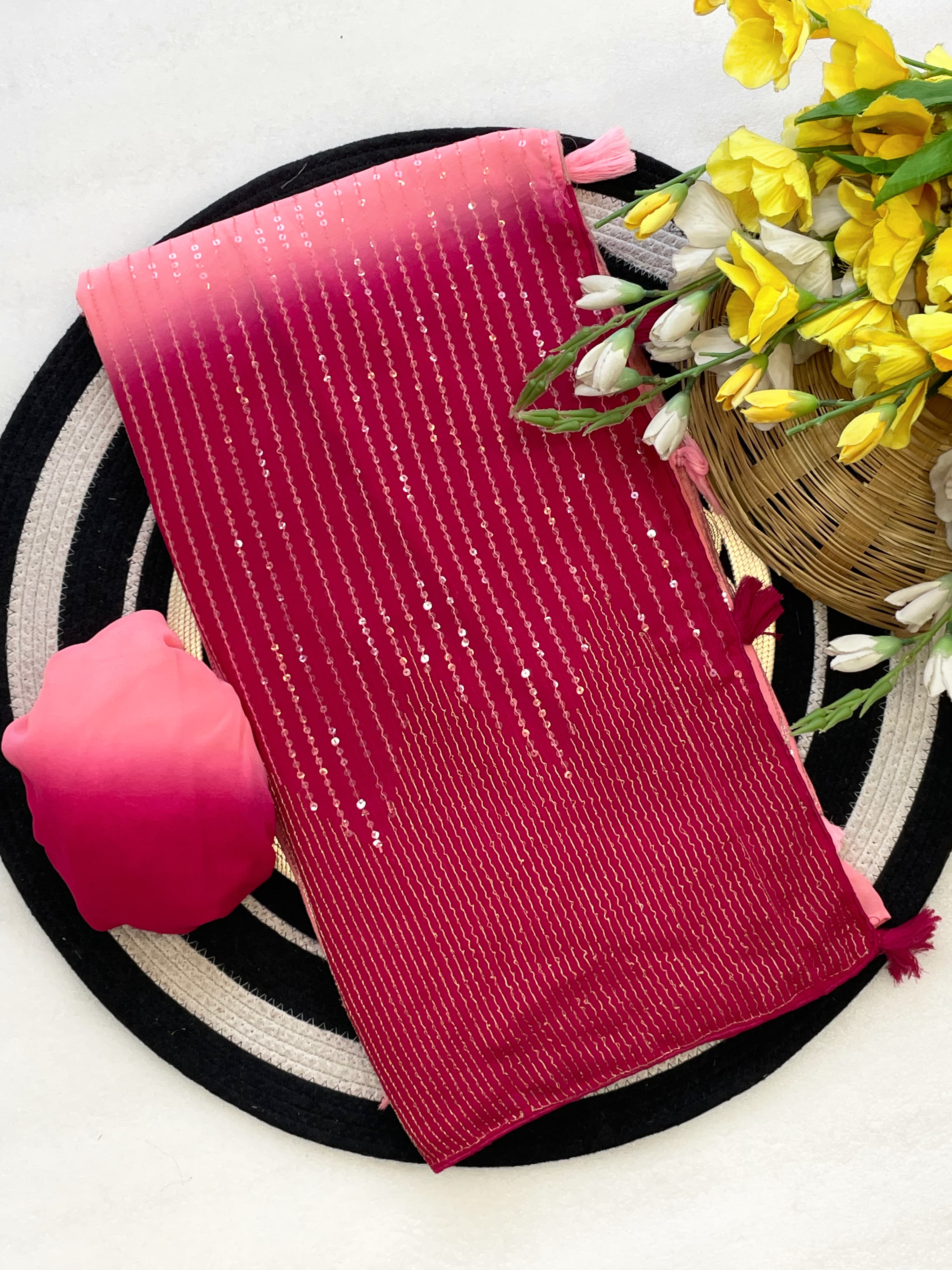 Pink textured fabric with a decorative flower arrangement on a white background