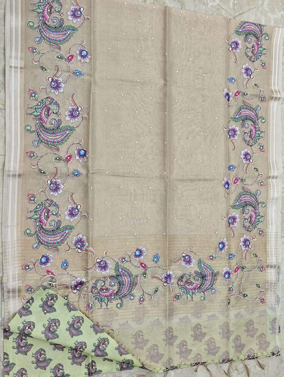 Beige 2 fabric with colorful floral and paisley patterns on a marble surface
