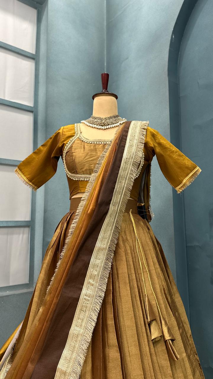 Gold and brown Traditional Indian saree on a mannequin against a blue wall